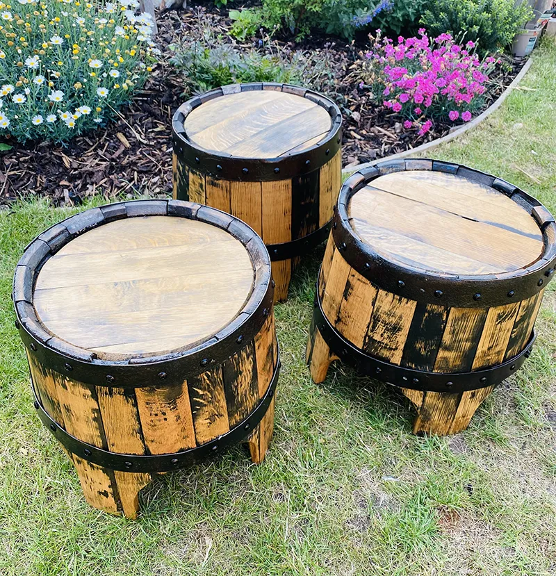 Three oak barrel tables set outdoors, by Thistle & Rose Events.